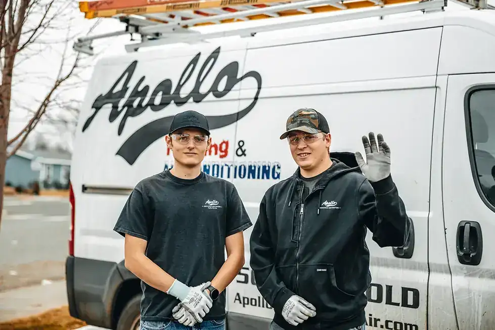 Two Apollo technicians standing in front of an Apollo service van