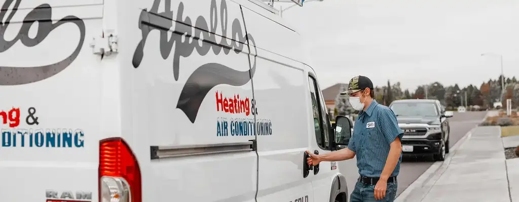 An Apollo technician at the open door of a service van