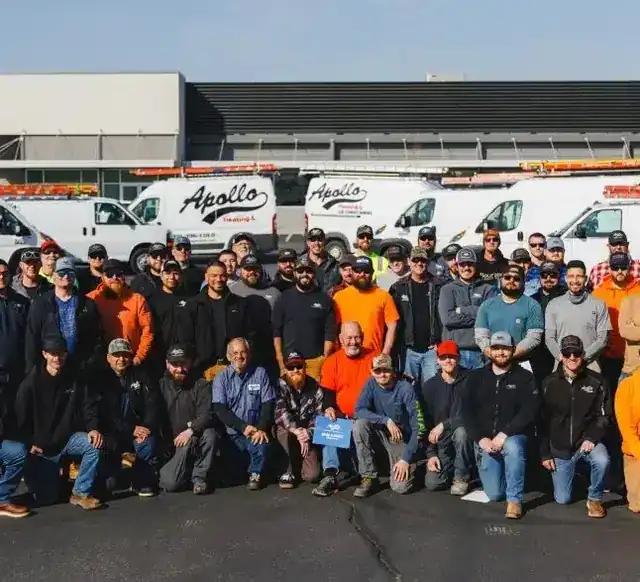 The Apollo crew in front of the company vans