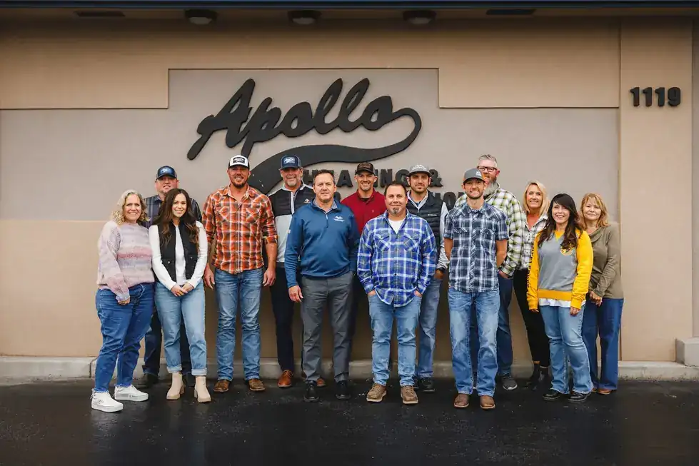 The Apollo team standing under the Apollo sign at 1119 W. Columbia Drive